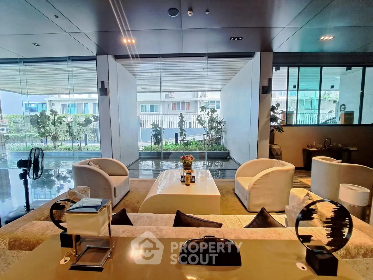 Luxurious modern living room with elegant furniture and large windows overlooking a serene garden view.
