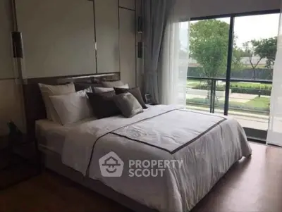 Luxurious bedroom with large window and garden view, featuring elegant decor and plush bedding.