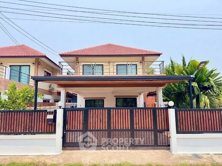 Charming two-story house with red roof and spacious front yard in a serene neighborhood.