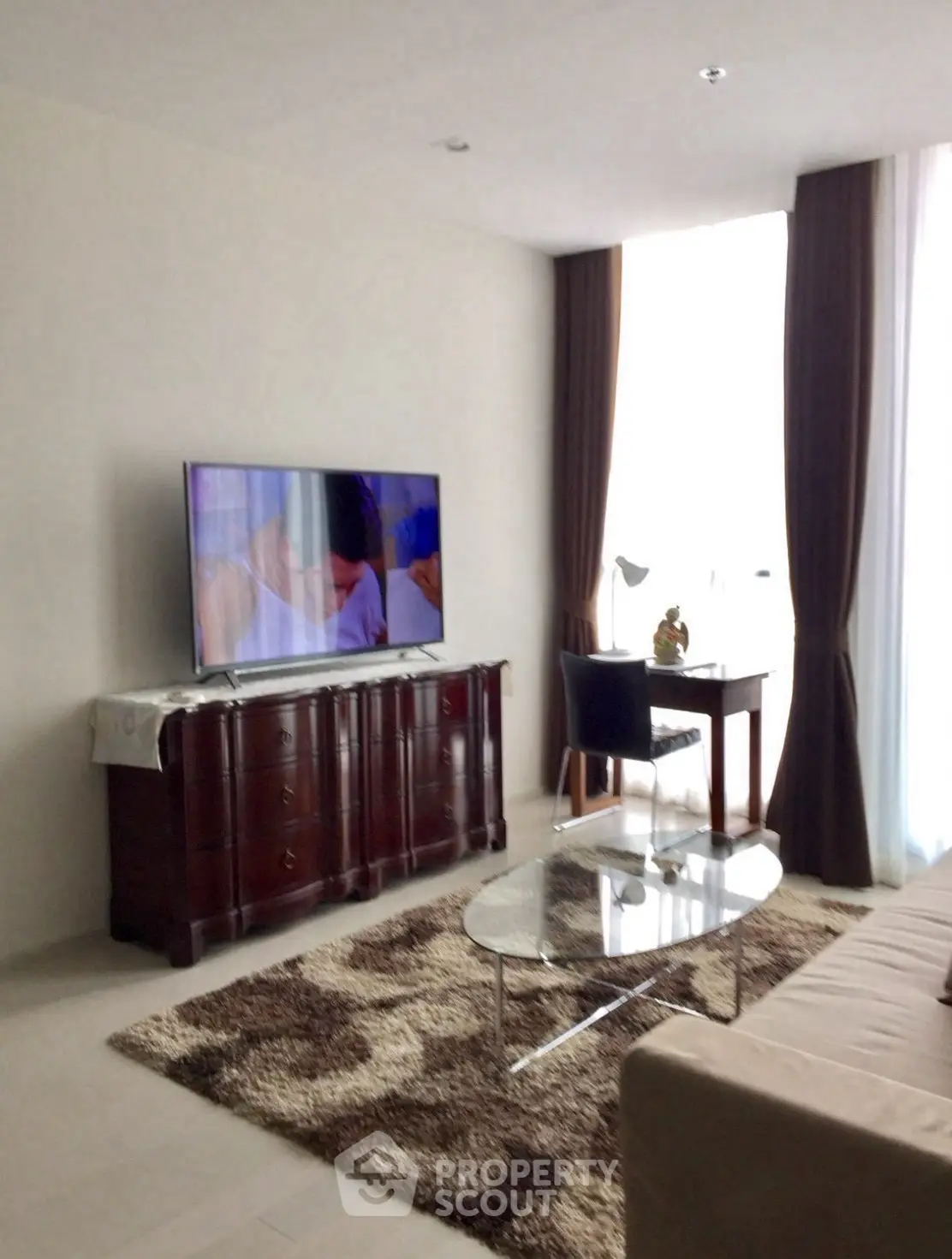 Modern living room with stylish furniture and large TV, perfect for relaxation.