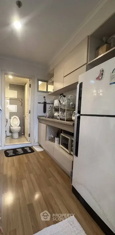 Compact kitchen with modern appliances and adjacent bathroom