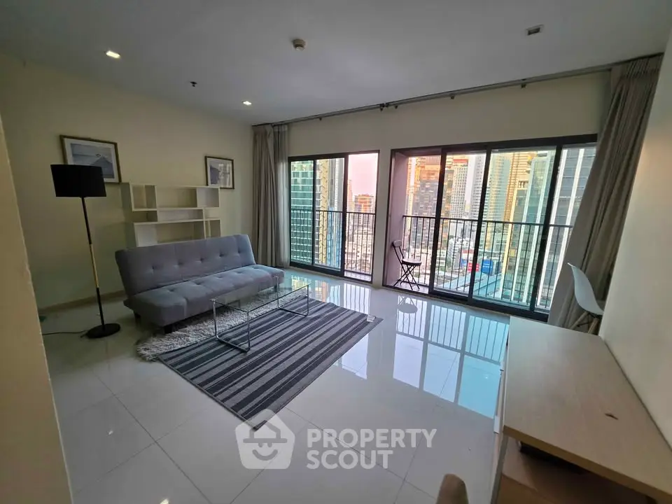 Modern living room with city view, featuring sleek furniture and large windows for natural light.