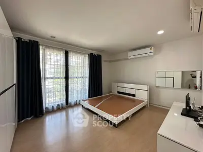 Spacious unfurnished bedroom with large windows and modern air conditioning.