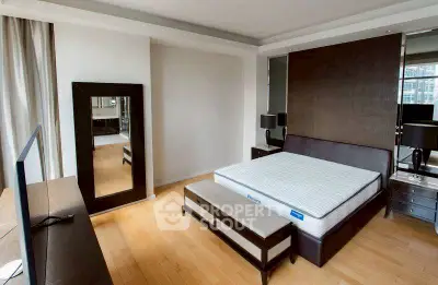 Spacious modern bedroom with sleek furniture and large mirror