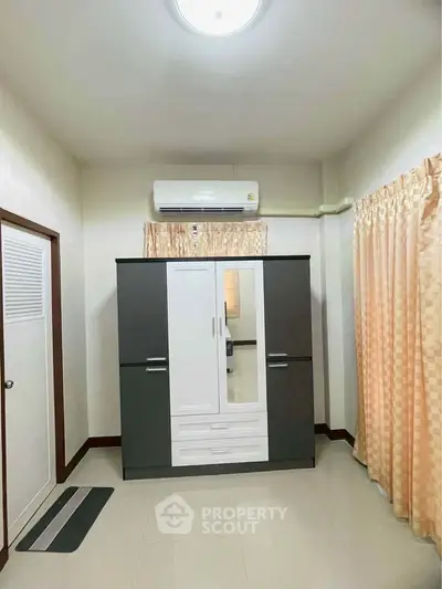 Spacious bedroom with modern wardrobe and air conditioning unit.