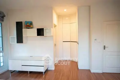Modern minimalist living room with sleek white furniture and wooden flooring