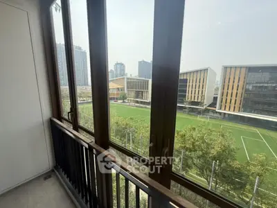 Spacious balcony with panoramic view of modern cityscape and sports field