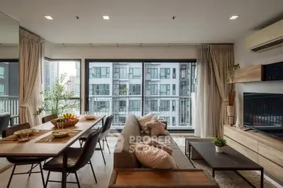Modern living room with elegant decor and city view from large windows.