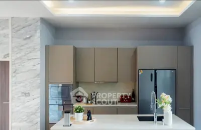 Modern kitchen with sleek design, featuring built-in oven and spacious fridge.