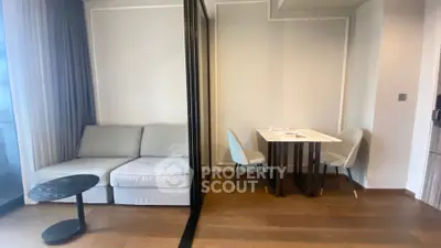 Modern apartment interior with cozy living area and dining space, featuring elegant furniture and wooden flooring.