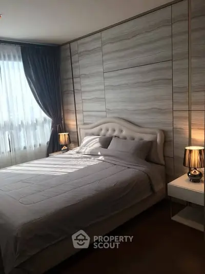 Luxurious bedroom with elegant decor and natural light, featuring a plush bed and stylish bedside lamps.