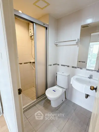 Compact bathroom with shower and modern fixtures in a cozy apartment.