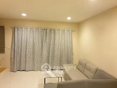 Cozy living room with modern gray sofa and elegant curtains