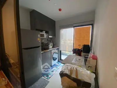 Compact kitchen with modern appliances and balcony view in urban apartment