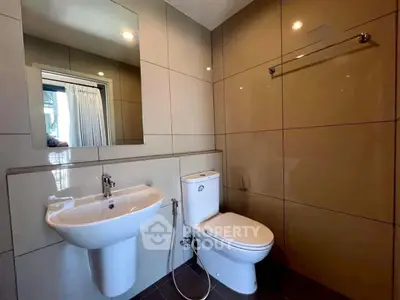 Modern bathroom with sleek fixtures and large mirror in contemporary apartment.