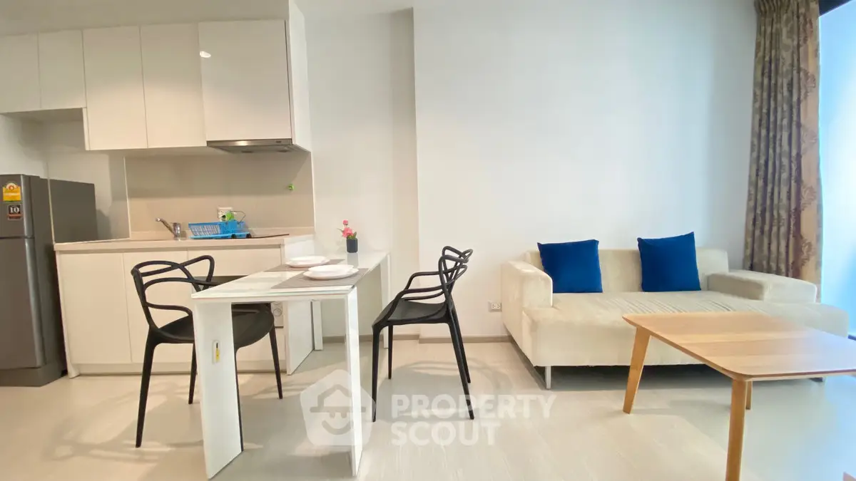 Modern open-plan living room with kitchen, stylish furniture, and bright decor.