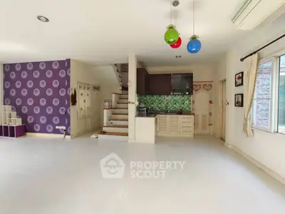 Spacious open-plan living area with modern kitchen and colorful decor