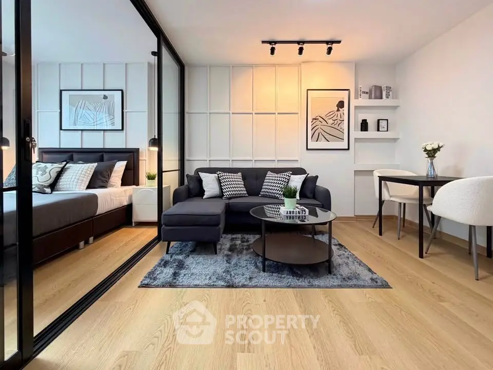 Modern open-plan living room with stylish decor and cozy bedroom area