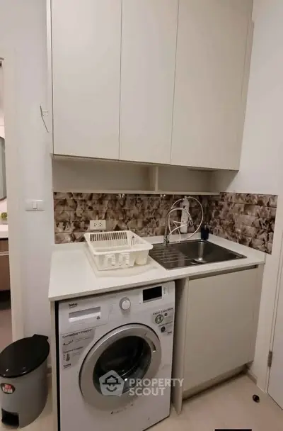 Compact kitchen with washing machine and modern cabinetry