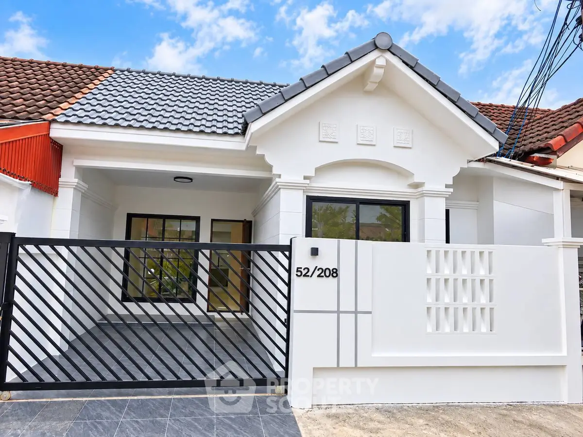 Charming single-story house with modern facade and gated entrance, perfect for family living.