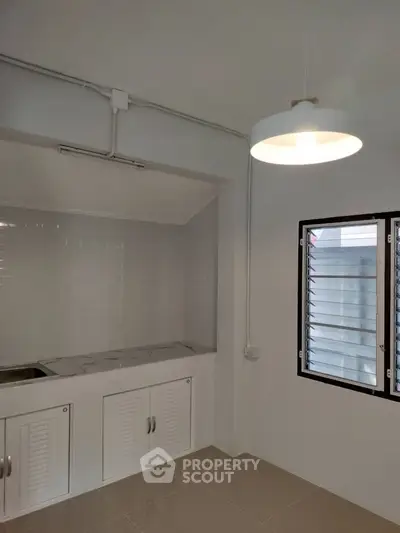 Minimalist kitchen with white cabinets and modern lighting