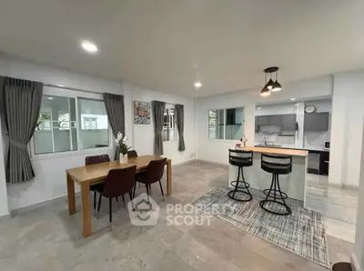 Spacious modern living area with open kitchen and dining space, featuring stylish decor and ample natural light.