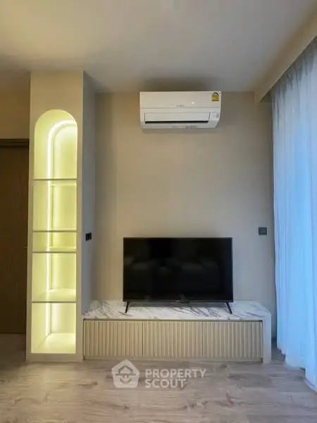 Modern living room with sleek TV setup and illuminated shelving