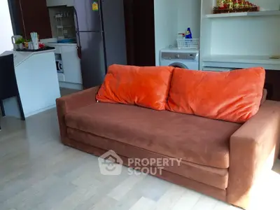 Cozy living room with plush brown sofa and modern kitchen appliances