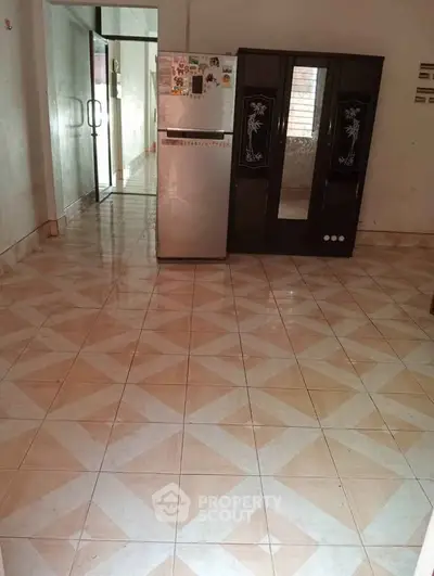 Spacious kitchen with tiled floor and refrigerator, ideal for modern living.