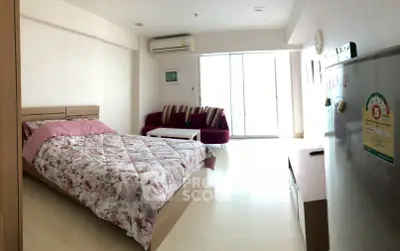 Cozy studio apartment with bed, sofa, and air conditioning, ideal for modern living.