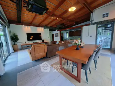Spacious open-plan living and dining area with modern decor and high ceilings.