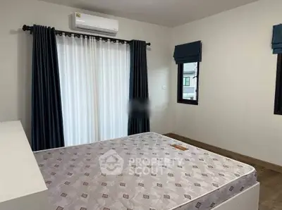 Spacious bedroom with large window and air conditioning, perfect for comfort and relaxation.