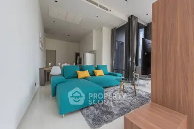Spacious modern living room with teal sofa and open layout in luxury apartment
