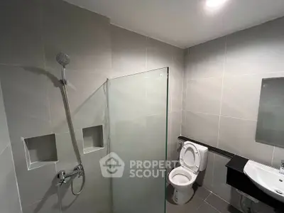 Modern bathroom with sleek shower and toilet in contemporary design.