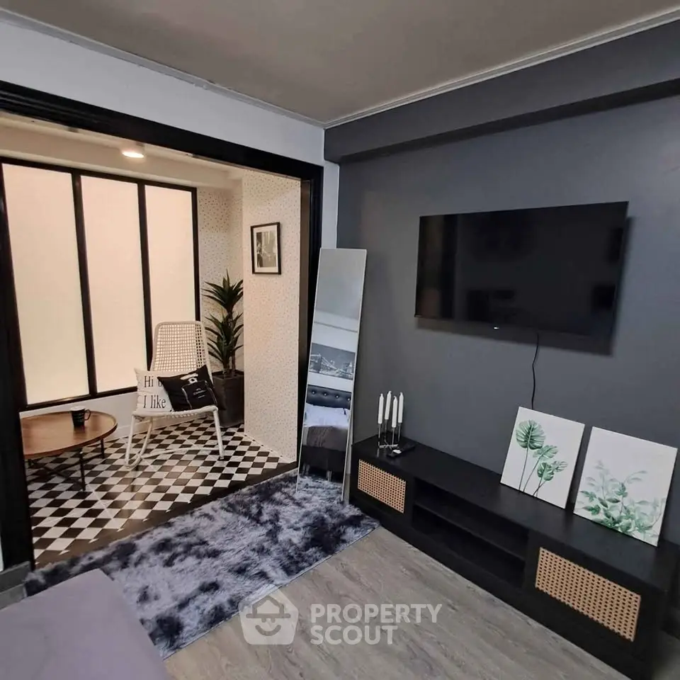 Stylish living room with modern decor and adjacent cozy sunroom featuring checkered flooring.
