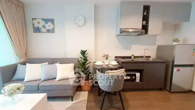 Modern open-layout living room and kitchen with stylish decor and cozy seating area.