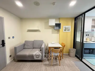 Modern living room with cozy sofa and dining area, featuring sleek design and open kitchen layout.