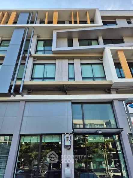 Modern multi-story building with sleek architectural design and large windows.