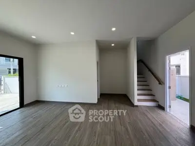 Spacious modern living room with wooden flooring and staircase