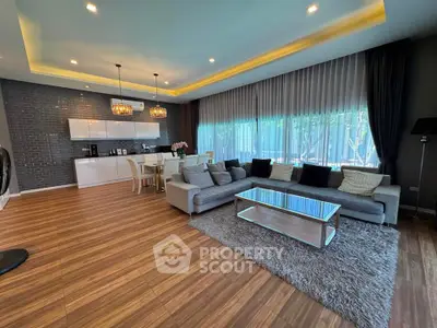 Spacious modern living room with elegant decor and large windows offering natural light.