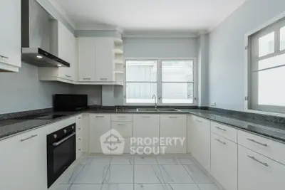 Modern kitchen with sleek white cabinets and granite countertops