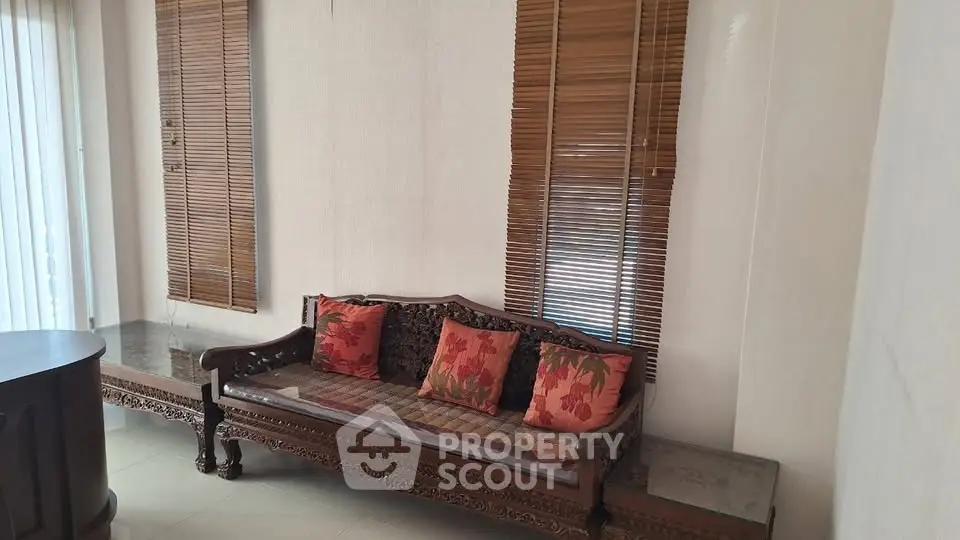 Elegant living room with carved wooden sofa and floral cushions