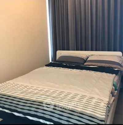 Cozy bedroom with modern decor and comfortable bedding in a stylish apartment.
