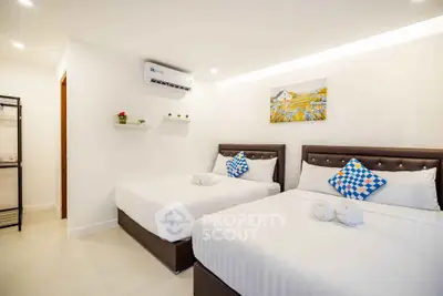 Spacious modern bedroom with two beds, air conditioning, and elegant decor.