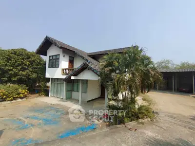 Charming two-story house with lush greenery and spacious driveway