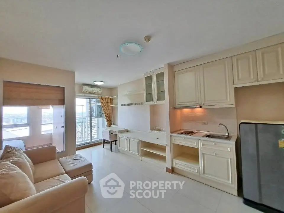 Cozy open-layout living room with kitchen and balcony view