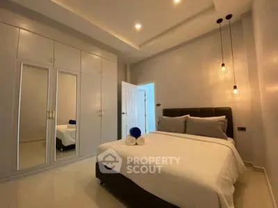 Modern bedroom with sleek design, mirrored wardrobe, and cozy lighting for a comfortable living experience.