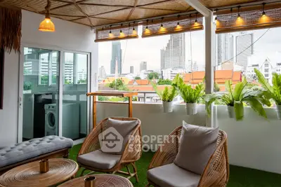 Chic balcony with city view, stylish seating, and lush plants