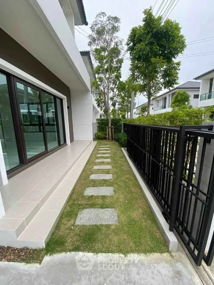 Modern house exterior with sleek design and lush garden pathway, perfect for contemporary living.