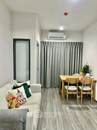 Cozy living room with modern decor and dining area, featuring a plush sofa and elegant curtains.
